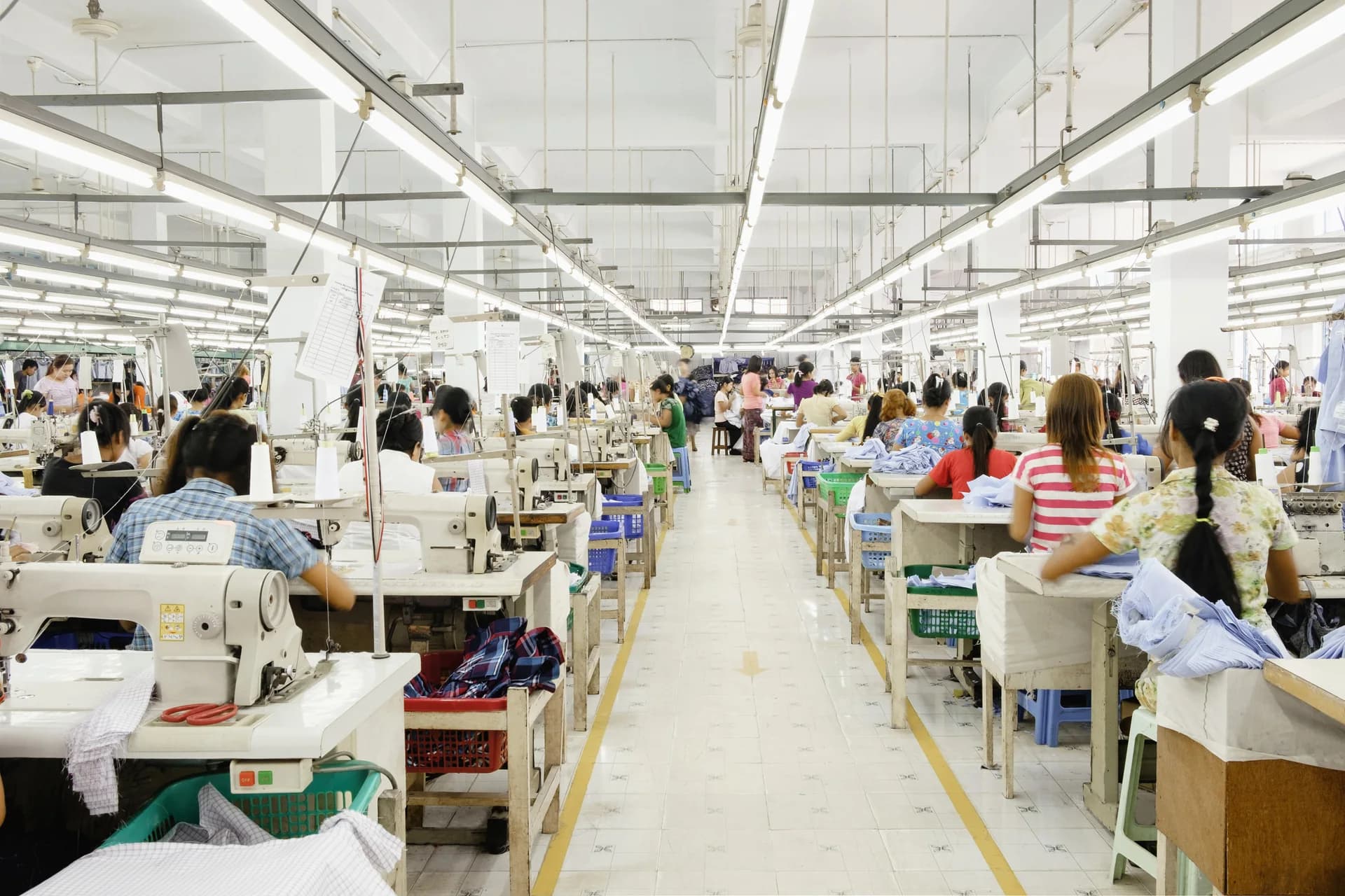 Garment sewing floor with parallel workstations, operators and fabric bundles